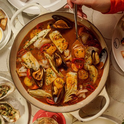 Festive seafood stew served into a round ceramic turreen