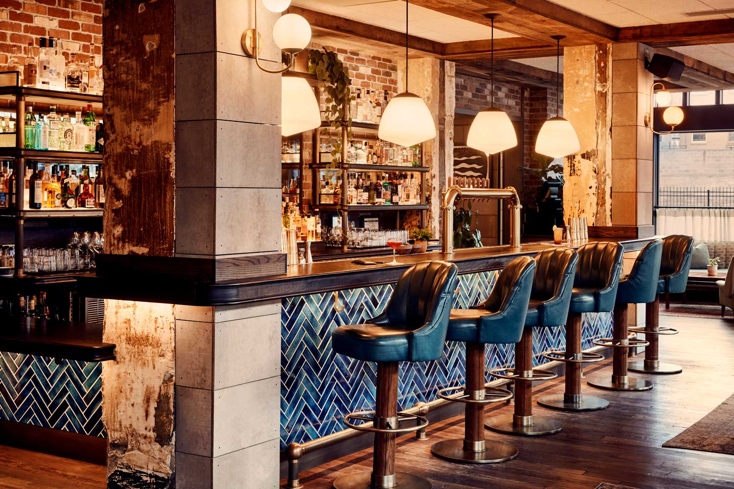 Warm lighting and stunning blue tiles characterise the bar area in Lovely Rita