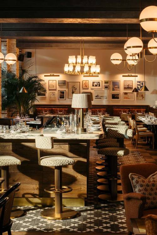 Bar area in the lobby restaurant, featuring plants and chandeliers