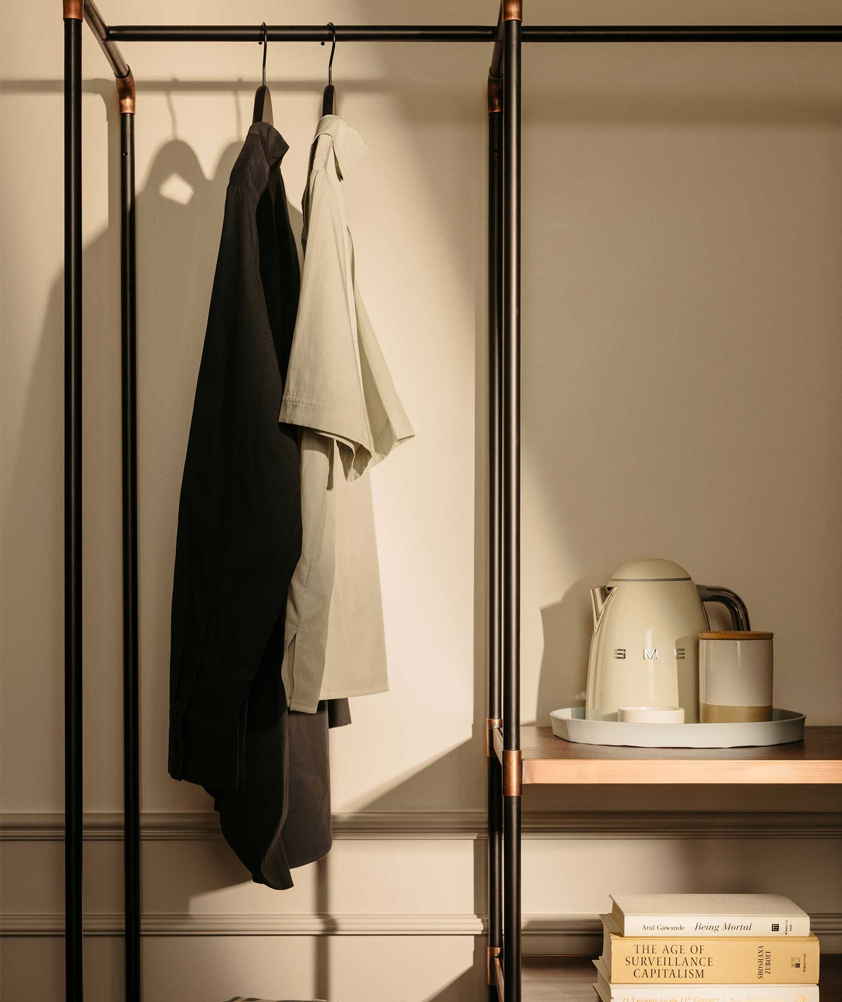 An area to hang clothes up, with kettle on a shelf