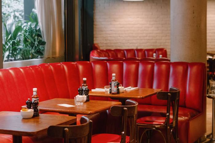 Red booths, table and chairs at Hoxton Grill.