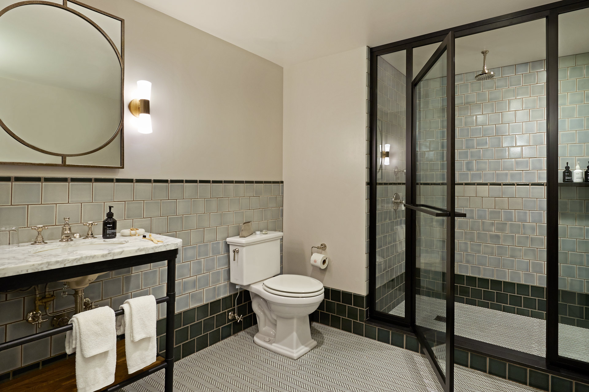 The bathroom has very pale blue-green tiles, with shower gel, shampoo and condition provided in the shower
