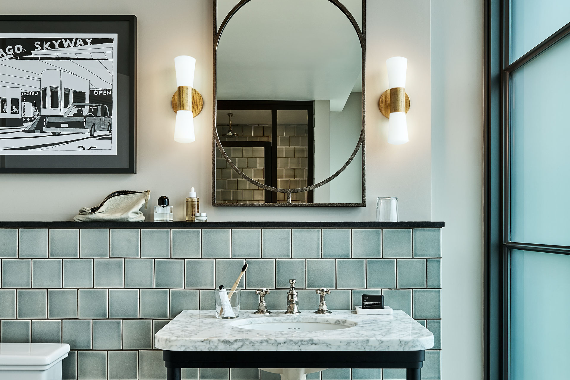 Marble sink below a mirror with side lights