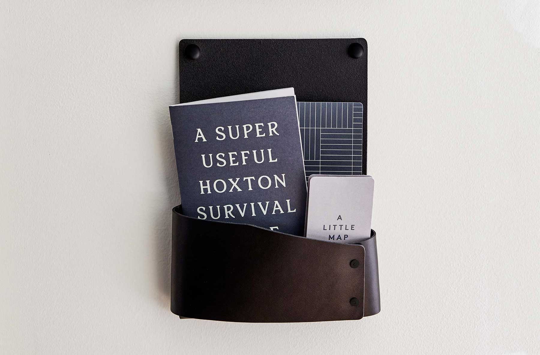 "A Super Useful Hoxton Survival Guide" and map sit in a holder on the wall