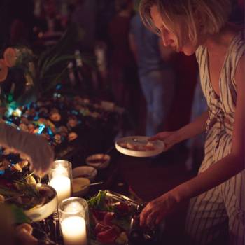 Frau holt Essen von einem Tisch auf einer Party