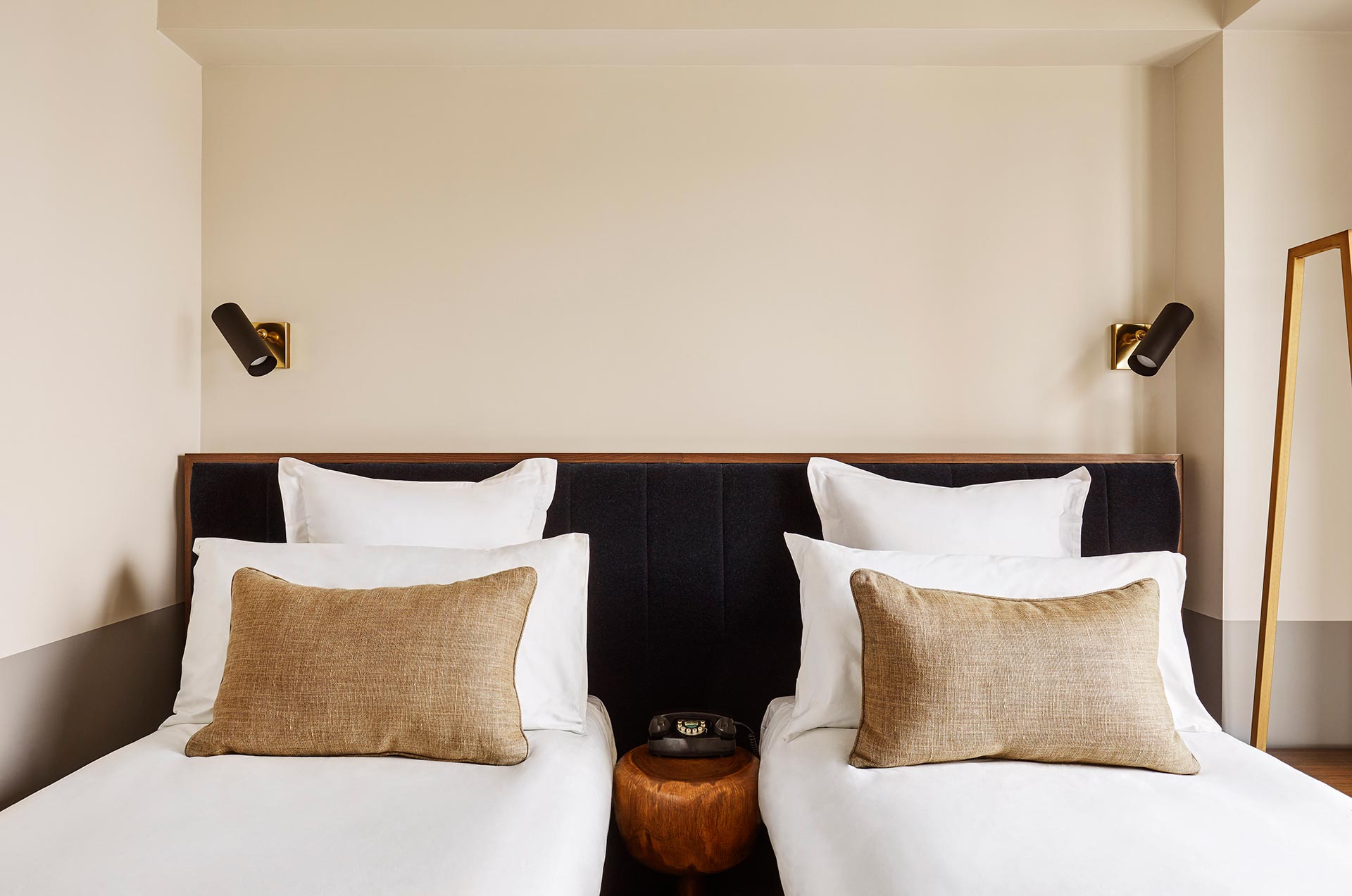 Two twin beds with a telephone on a table in between them.