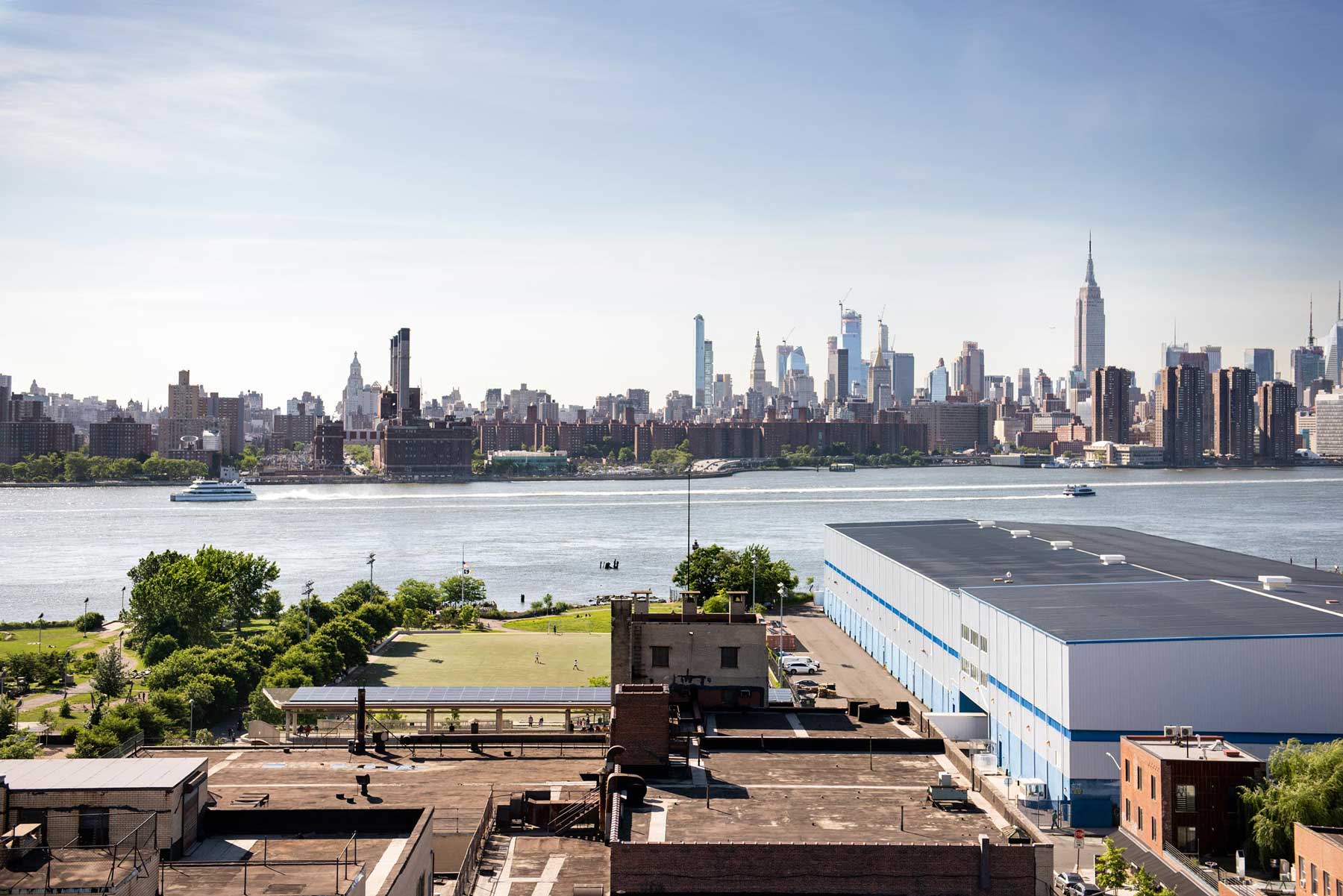 View of the Manhattan skyline across the River Hudson on a blue sky day