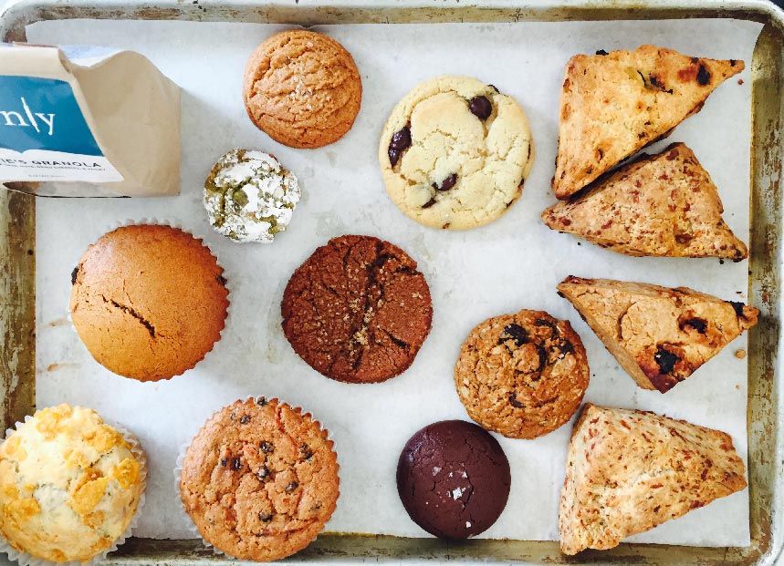Un plateau de biscuits, de muffins, de granola et d'autres produits de boulangerie.