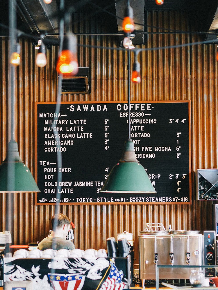 Panneau de menu montrant différentes boissons chaudes et les prix dans un café