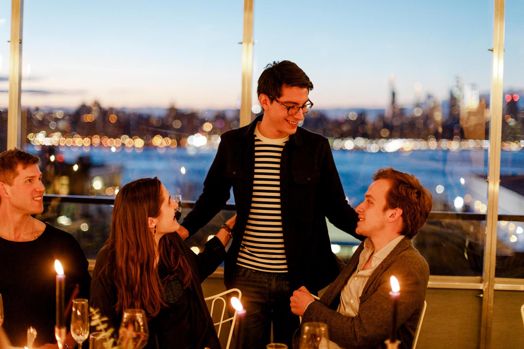 People at a party on the rooftop of the hotel, with a stunning view of Manhattan in the background