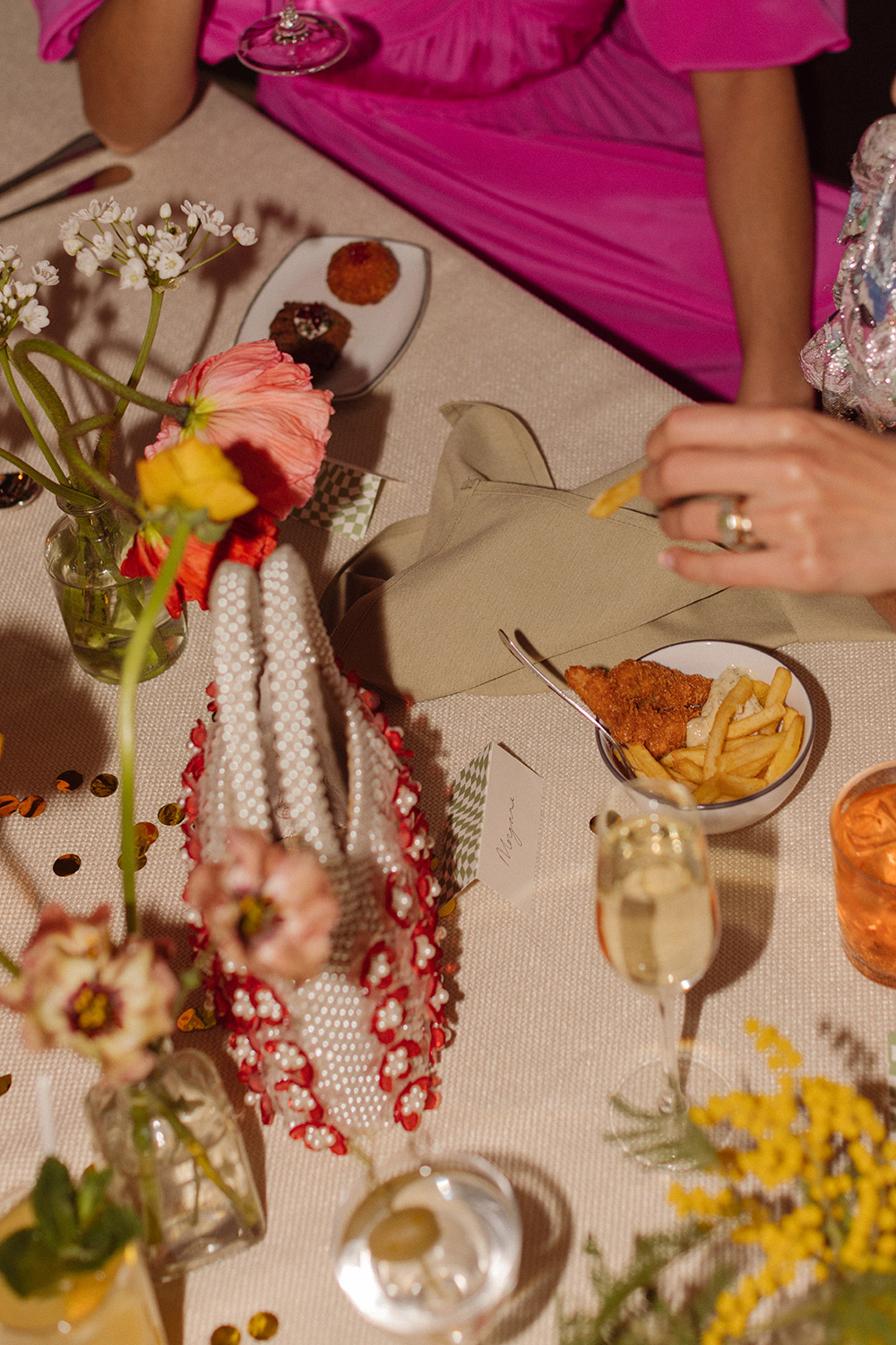 Table laid for a wedding with cocktails and flowers.