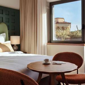 Blue sky is shown outside of the hotel room, which has a small balcony