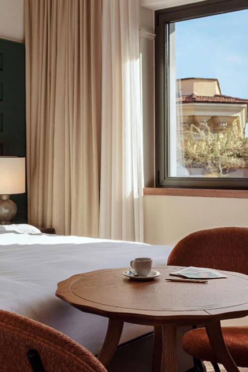 Blue sky is shown outside of the hotel room, which has a small balcony