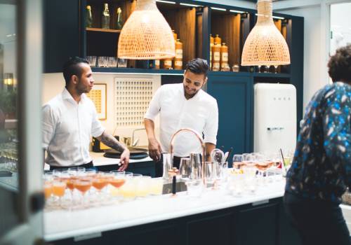 Staff in a white uniform, working behind the bar at an event