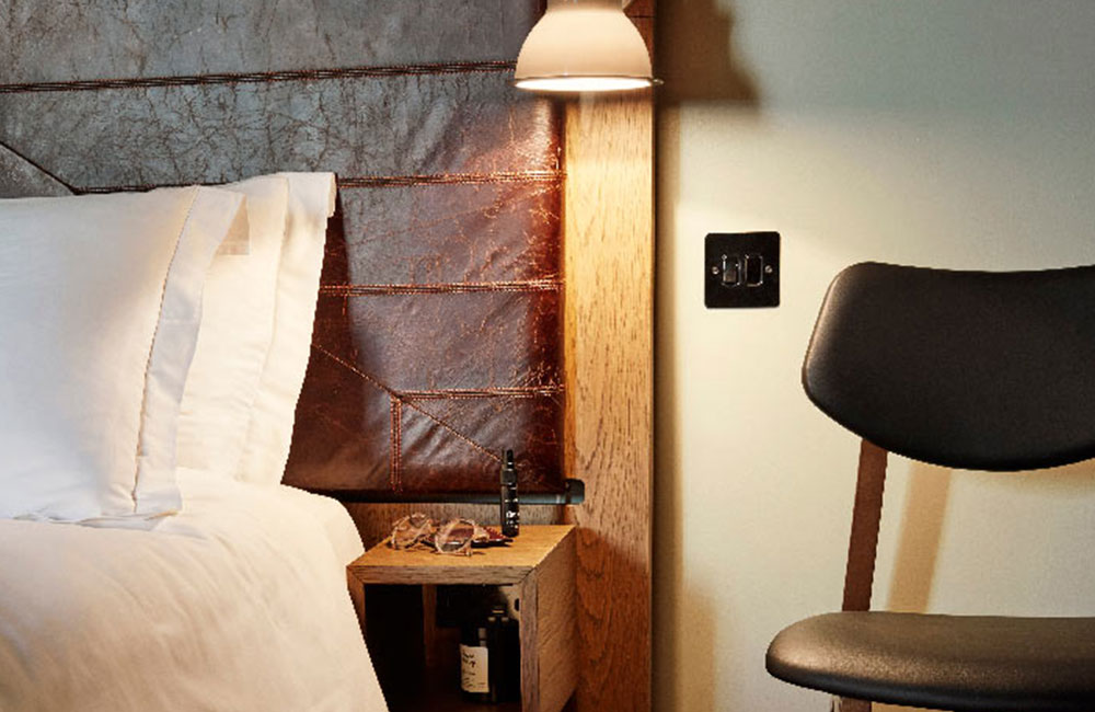 Leather headboard behind bedside table with lamp