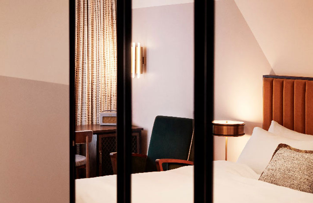 Bed and lounge chair reflected in the mirror