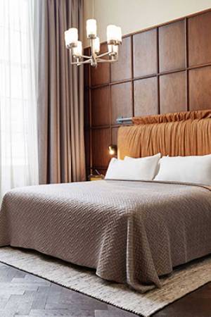 Larger room in Amsterdam hotel with wooden panelling behind the bed