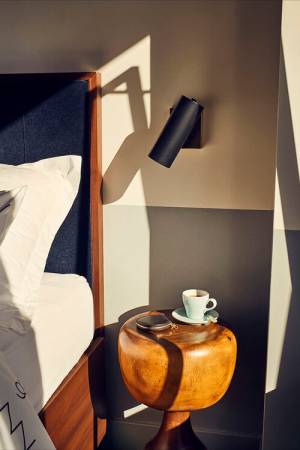 Coffee on side table beside bed in Williamsburg hotel room