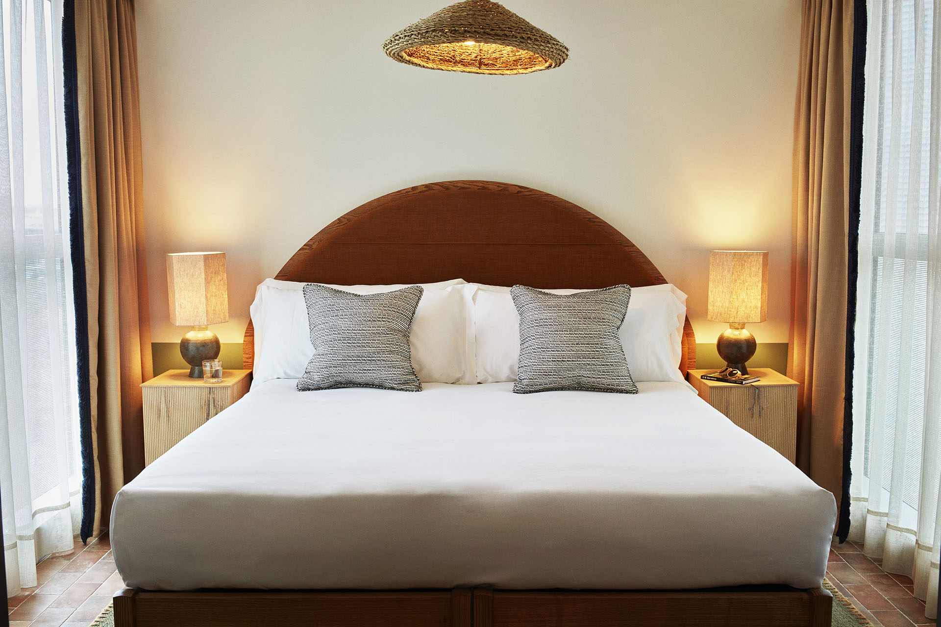 A large double bed with circular headboard and bedside tables