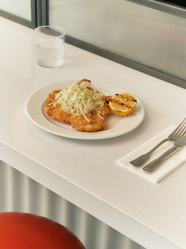 Bar counter with a dish, glass of water and utensil.