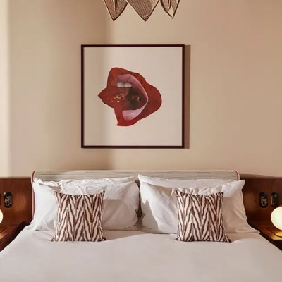 Bed with lips artwork above it