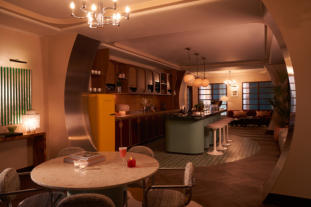 Stylish party space available to rent with bar, stools, chairs, tables and stylish curved surfaces.