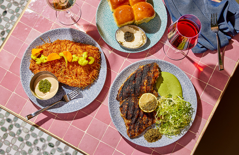 Spread of K'Far food and wine outside on a sunny day.