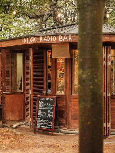 Shows Kiosk Radio amid the trees of Parc Royal.
