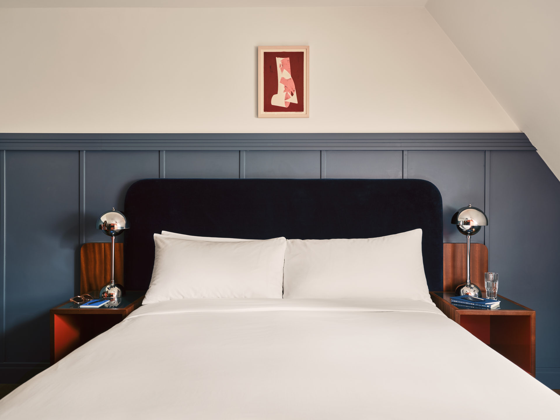 Facing shot of the bed with pillows and blue and white walls