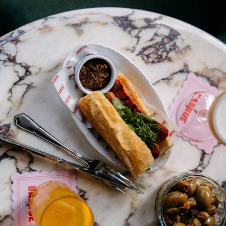 Drinks and snacks served on a marble table at the Barbue bar