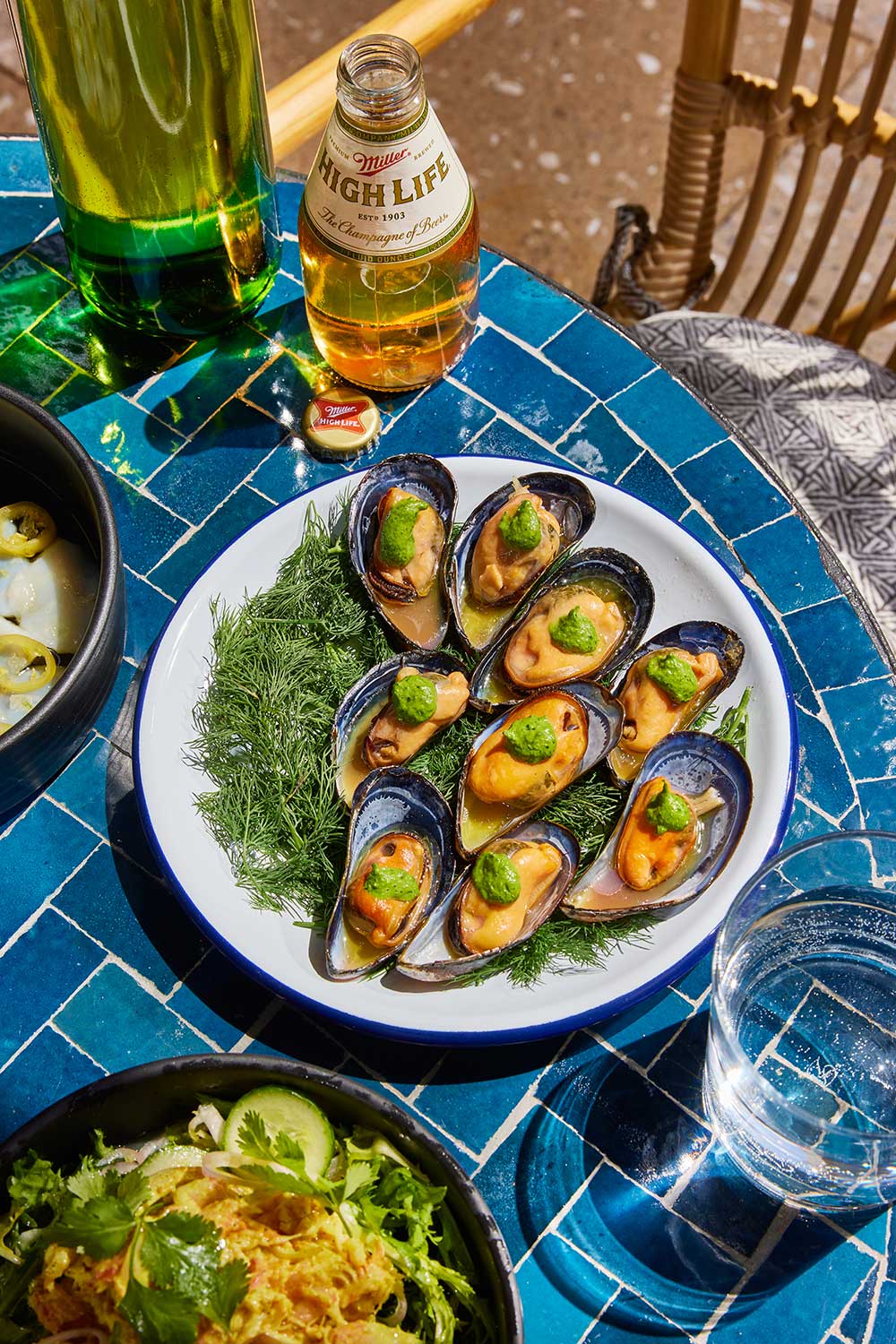 Bed of seasoned oysters on a blue terracotta table.