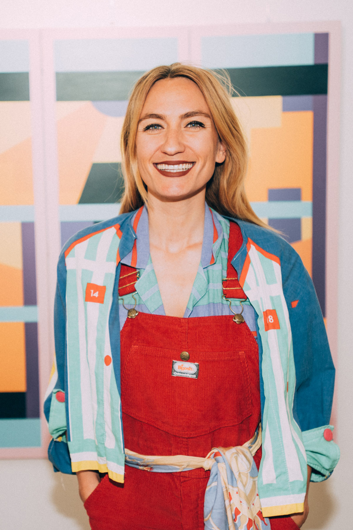 Die Pariser Künstlerin Caroline Derveaux lächelt vor ihrem Kunstwerk