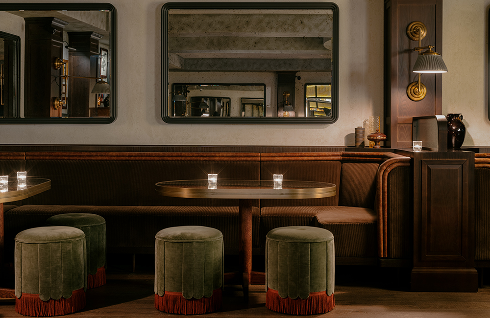 View of booths with wall mounted chairs and free-standing pouffes.