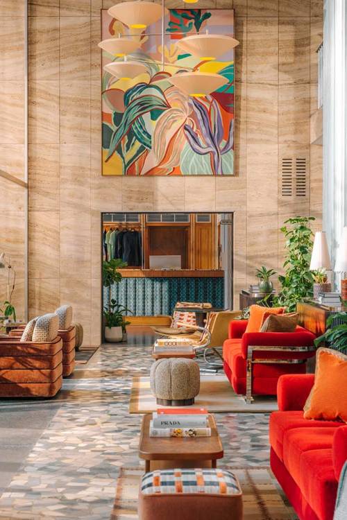 View of the Hoxton Vienna lobby, large windows and natural light reflecting on to the furnitures like bright velvet sofas coffee tables and soft armchairs.