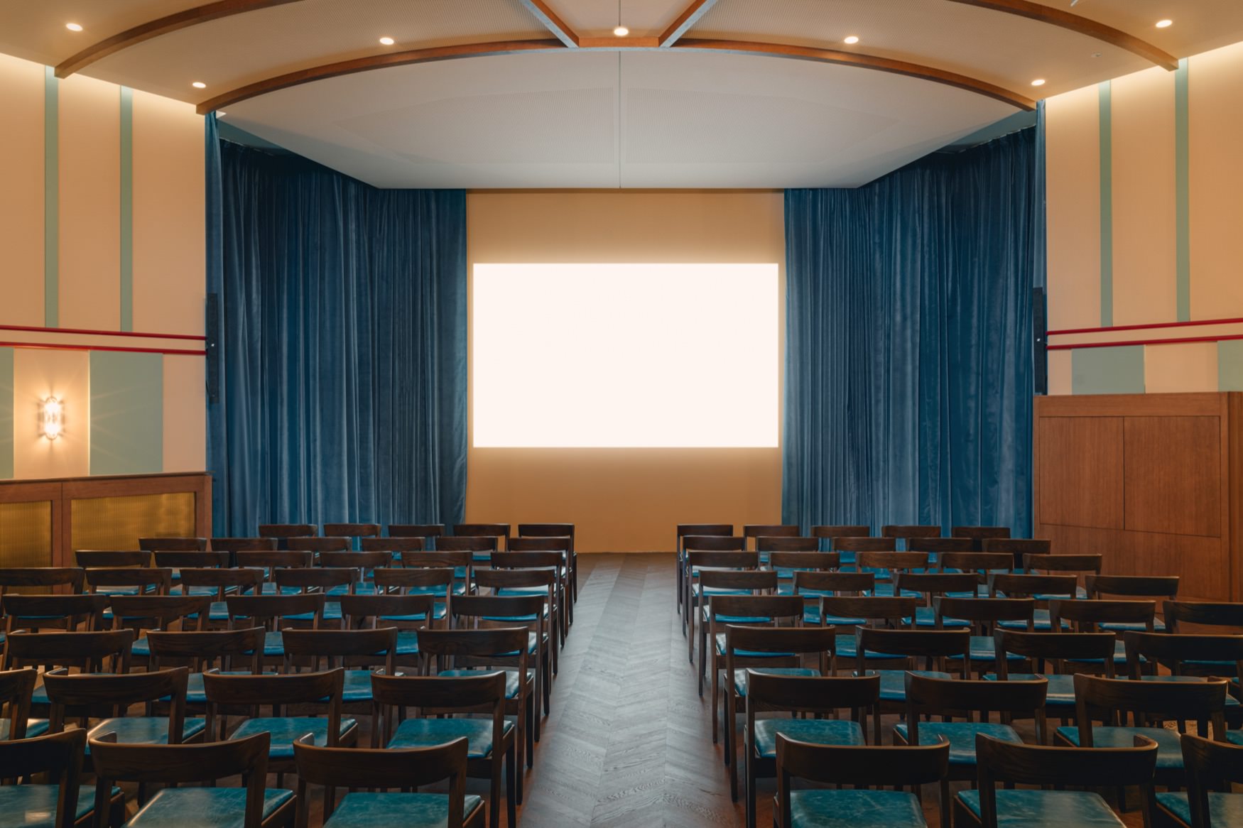 Teatre layout with row of chairs facing a screen.