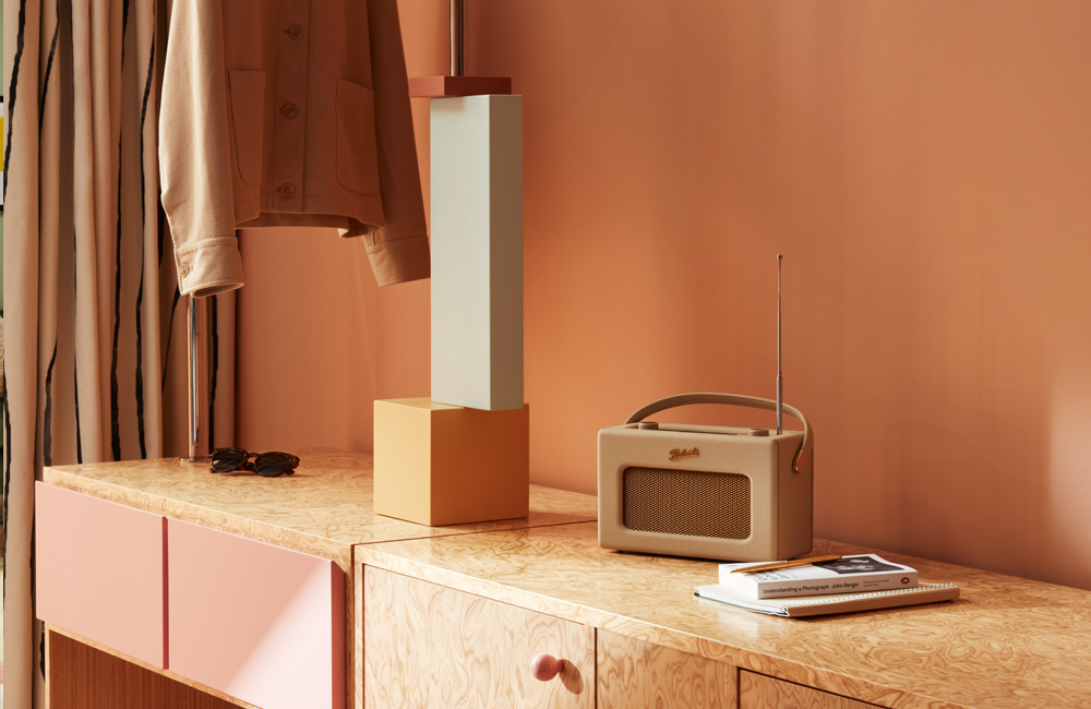 Radio and a coral and pink glass lamp resting on a table.